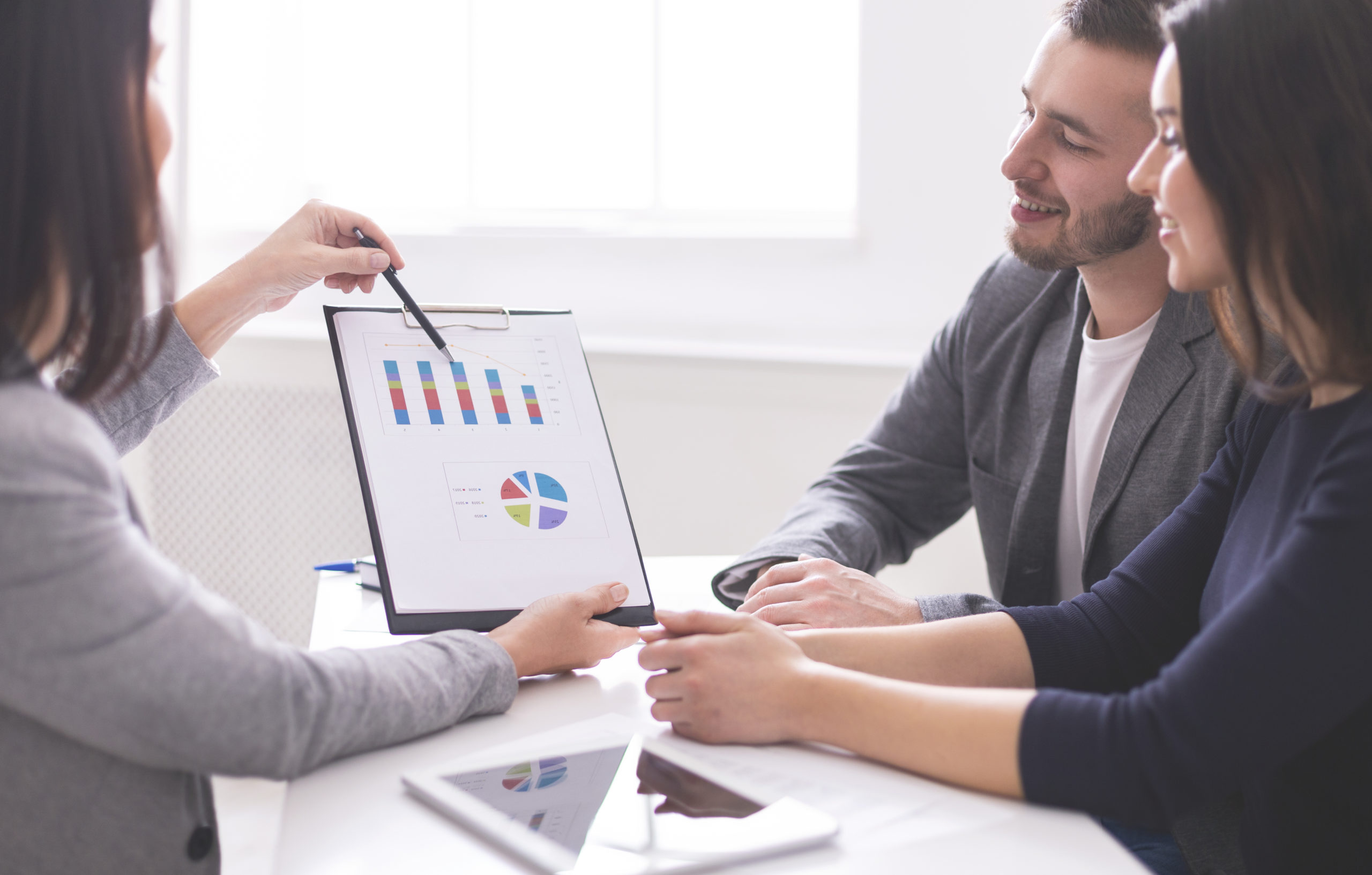 Financial advisor showing numbers to a young couple